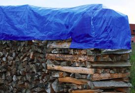bâche de protection pour mobilier de jardin en polyéthylène sur tas de bûches