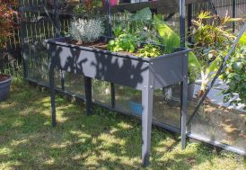 jardinière urbaine sur pieds remplie dans un jardin
