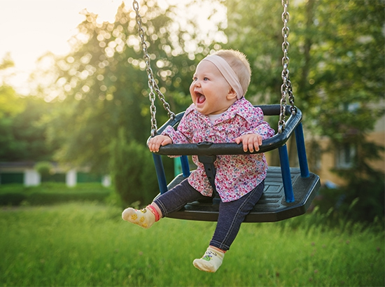 Bébé riant sur une balançoire