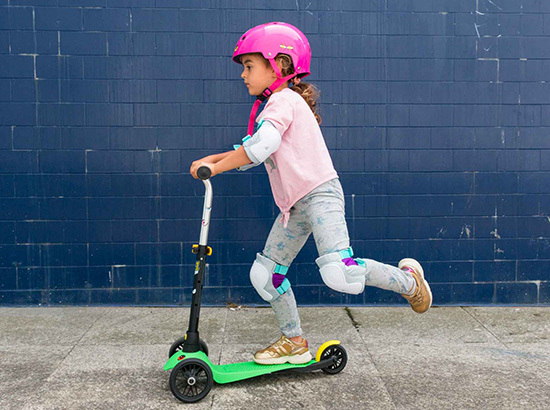 Petite fille en trottinette avec protections